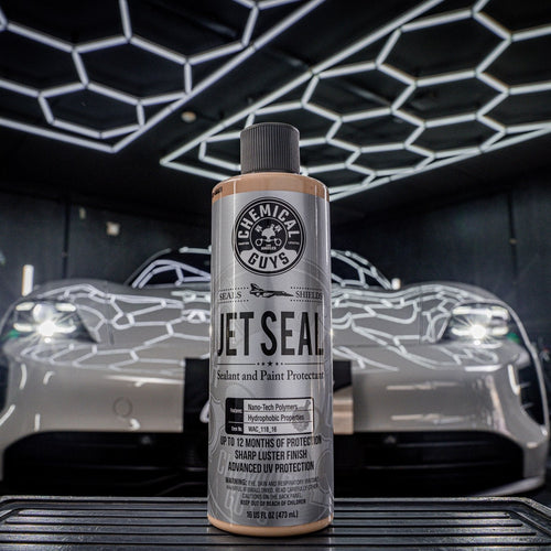 Car wax bottle with a car in the background in a garage setting